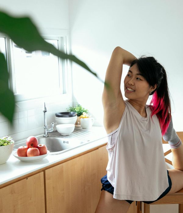 Young woman practicing balance yoga pose in warm lighting environment